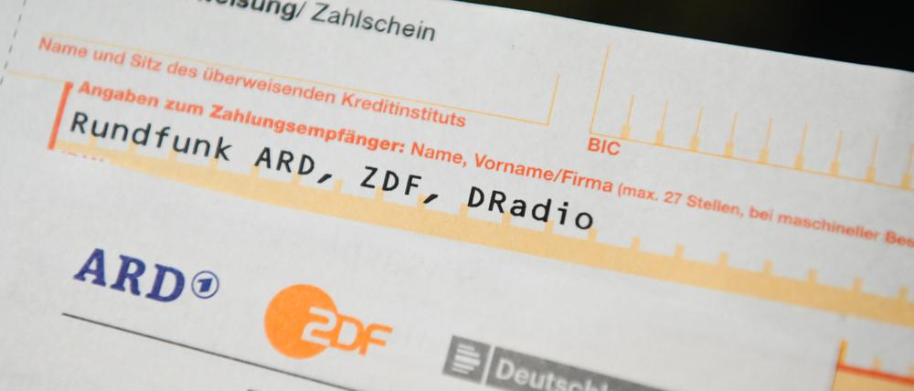 Auf einem Tisch liegt ein Anschreiben und Überweisungsträger für die Rundfunkgebühren. 