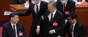 Hu Jintao (M), ehemaliger Präsident von China, wird aus der Abschlusszeremonie des 20. Nationalen Kongresses der Kommunistischen Partei Chinas in der Großen Halle des Volkes hinausbegleitet.