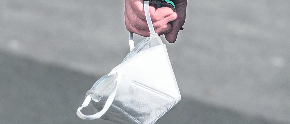 Eine Person hält eine FFP2-Maske in der Hand. (Symbolbild)