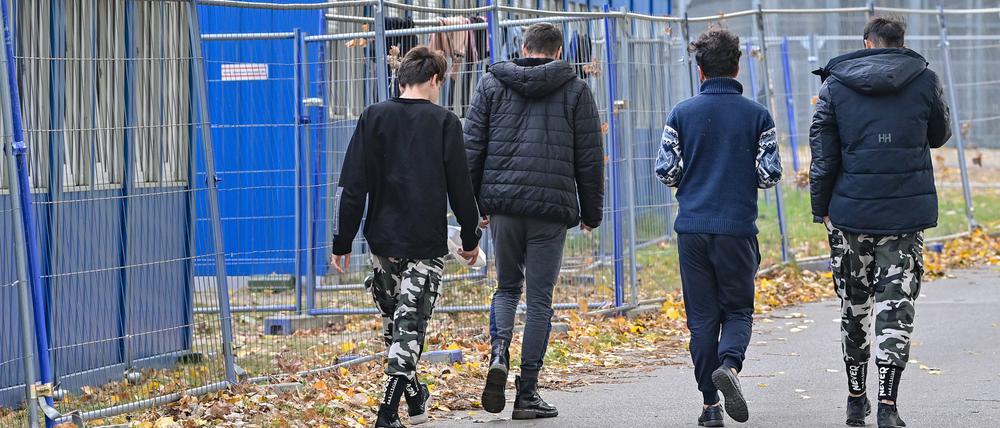 Flüchtlinge gehen über das Gelände der Zentralen Erstaufnahmeeinrichtung für Asylbewerber (ZABH) des Landes Brandenburg in Eisenhüttenstadt.