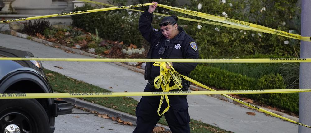 Eine Polizistin blockiert mit gelbem Absperrband die Straße unterhalb des Hauses von Paul Pelosi, dem Ehemann der Demokratin Nancy Pelosi, in San Francisco.