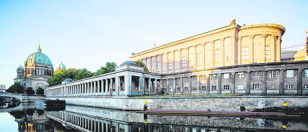 Die Alte Nationalgalerie (r.) und der Berliner Dom (l.) spiegeln sich im Licht der aufgehenden Sonne in der Spree.