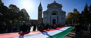 Eine italienische Flagge wird von Mussolini-Anhängern am Grab des Diktators getragen