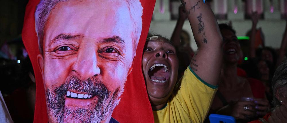 TOPSHOT - A supporter of Brazilian former President (2003-2010) and candidate for the leftist Workers Party (PT) Luiz Inacio Lula da Silva celebrates after her candidate won the presidential runoff election at the Cinelandia square in Rio de Janeiro, Brazil, on October 30, 2022. - Brazil's veteran leftist Luiz Inacio Lula da Silva was elected president Sunday by a hair's breadth, beating his far-right rival in a down-to-the-wire poll that split the country in two, election officials said. (Photo by Pablo PORCIUNCULA / AFP)