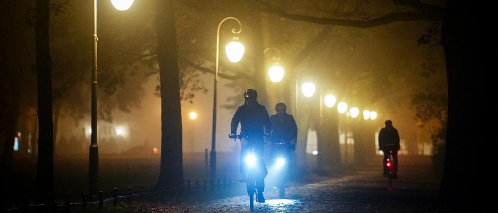 31.10.2022, Berlin: Radfahrer fahren am Abend durch den nebeligen Tiergarten. Foto: Kay Nietfeld/dpa +++ dpa-Bildfunk +++