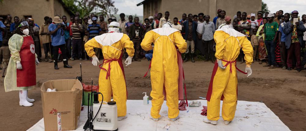 Mitarbeiter des Roten Kreuzes ziehen Schutzanzüge an, bevor sie am 13. Oktober in Mubende einen 3-jährigen Jungen beerdigen, der wohl an Ebola verstorben ist.