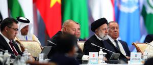 Der iranische Prräsident Ebrahim Raisi sitzt dem russischen Außenminister Sergei Lavrov während einer Konferenz gegenüber. 