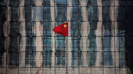 Chinas Nationalflagge vor einer Bank in Peking