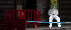 Ein Polizist in Schutzkleidung bewacht den Eingang eines Gebäudes (Symbolbild).