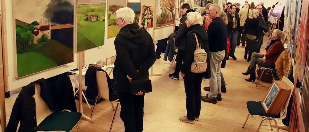 Besucher:innen betrachten Kunst beim 12. Teltower Kunst-Sonntag im Stubenrauchsaal