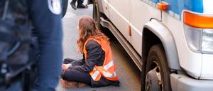 A climate activist of the organisation 'Die letzte Generation' (The Last Generation) is pictured after having been arrested by police after vandalising the facade of a building housing the federal office of Germany's liberal Free Democratic Party FDP in central Berlin on November 3, 2022. (Photo by MICHELE TANTUSSI / AFP)