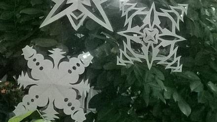 Selbstgebastelte Weihnachtssterne und Schneeflocken aus Papier.