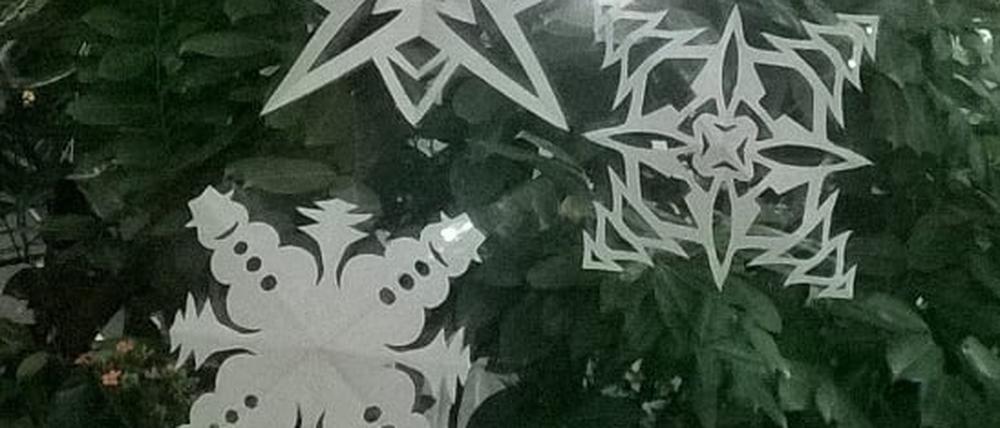 Selbstgebastelte Weihnachtssterne und Schneeflocken aus Papier.