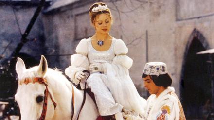 Der Prinz (Pavel Travnicek) passt Aschenbrödel (Libuse Safrankova) im Film „Drei Haselnüsse für Aschenbrödel“ den verlorenen Schuh an.
