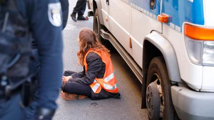 A climate activist of the organisation 'Die letzte Generation' (The Last Generation) is pictured after having been arrested by police after vandalising the facade of a building housing the federal office of Germany's liberal Free Democratic Party FDP in central Berlin on November 3, 2022. (Photo by MICHELE TANTUSSI / AFP)