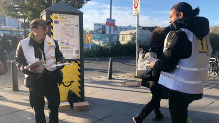 BVG-Mitarbeiter Marco (links) und sein Kollege verteilen am Kurt-Schumacher-Platz Info-Flyer und weisen Pendlern den Weg.  Foto: Alexander Kloß