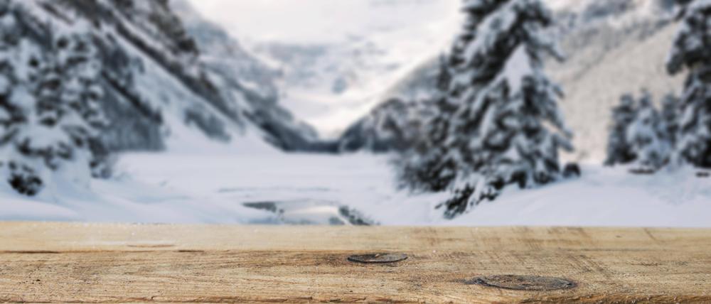 Holzplatte, Berge, Bäume und Schnee.