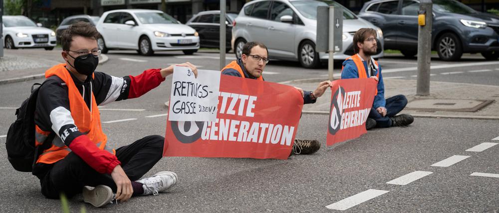 ARCHIV - 16.05.2022, Baden-Württemberg, Stuttgart: Drei Klimaaktivisten der Gruppe «Aufstand der letzten Generation» blockieren eine Straße in Stuttgart. Für mehrere solcher Blockaden müssen sich Mitglöieder der Gruppe «Aufstand der letzten Generation» in Stuttgart vor dem Amtsgericht verantworten. (zu dpa «Klimaaktivisten wegen Straßenblockaden in Stuttgart vor Gericht») Foto: Marijan Murat/dpa +++ dpa-Bildfunk +++