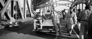 Am Grenzübergang Bornholmer Straße strömen auch am 10. November 1989 Ost-Berliner nach West-Berlin. Zwei Ost-Berliner sitzen mit einer Deutschlandfahne auf ihrem Dacia 1300. Bürgerinnen und Bürger aus West-Berlin begrüßen die DDR-Bürger.