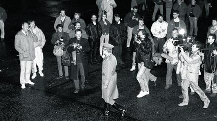 Historisches Momentum. Ein Grenzsoldat der DDR geht am 9. November 1989 in Ost-Berlin zur Mauer, beobachtet von Passanten, Fotografen, Hörfunk- und Fernsehreportern, darunter Teams des Senders Freies Berlin.