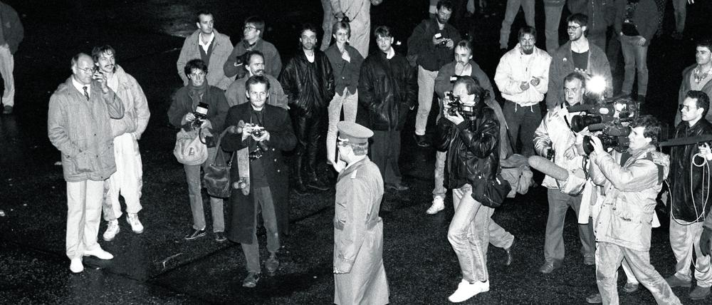 Historisches Momentum. Ein Grenzsoldat der DDR geht am 9. November 1989 in Ost-Berlin zur Mauer, beobachtet von Passanten, Fotografen, Hörfunk- und Fernsehreportern, darunter Teams des Senders Freies Berlin. 