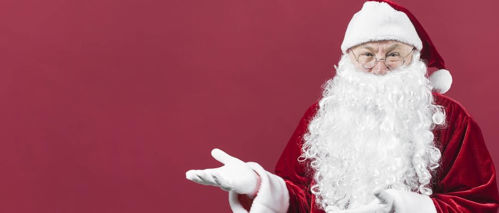 Weihnachtsmann zeigt etwas mit den Händen.