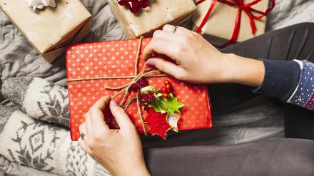 Weihnachtsgeschenke werden mit einer Schleife verziert.