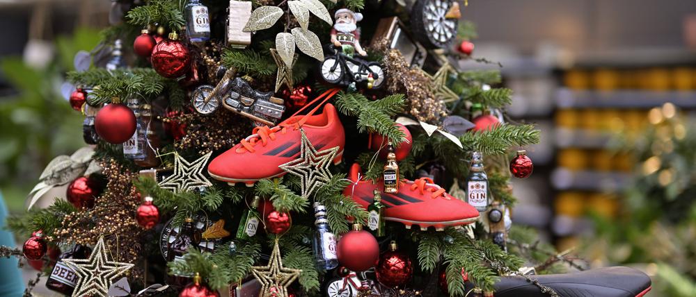 Fussballschuhe hängen an einem Weihnachtsbaum in einer Gärtnerei.