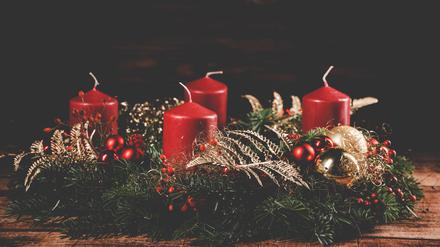 Ein Adventskranz mit vier roten Kerzen. 