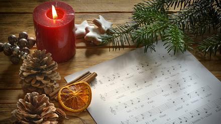 Musiknoten liegen neben weihnachtlicher Dekoration.