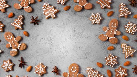 Lebkuchenmänner und Lebkuchen in Form von Tannenbäumen und Schneeflocken sind im Kreis angeordnet.