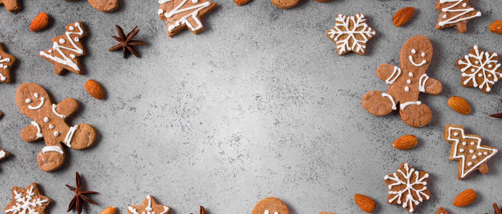 Lebkuchenmänner und Lebkuchen in Form von Tannenbäumen und Schneeflocken sind im Kreis angeordnet.