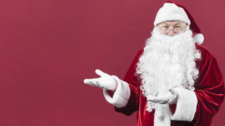 Weihnachtsmann zeigt etwas mit den Händen.
