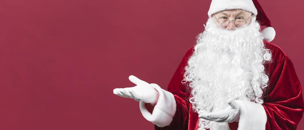 Weihnachtsmann zeigt etwas mit den Händen.