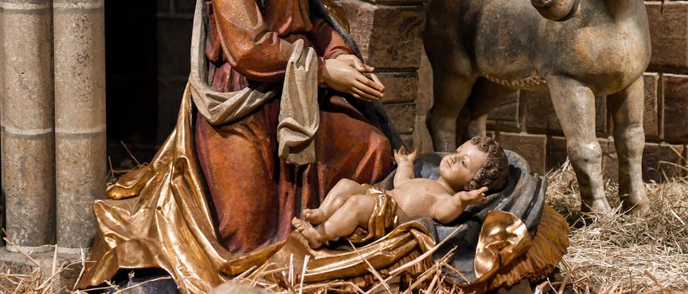 Maria mit dem Jesuskind im Stall von Bethlehem in einer Weihnachtskrippe mit der Heiligen Familie im Freiburger Münster. 