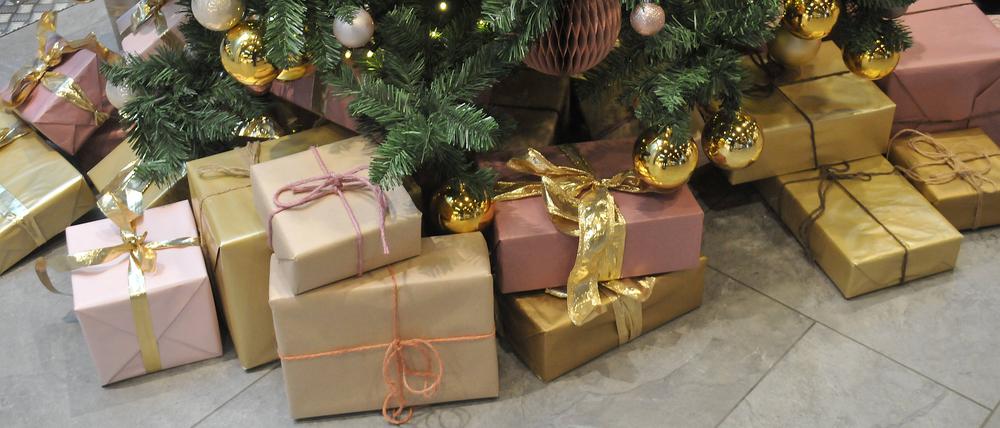 Weihnachtsgeschenke liegen unter einem Tannenbaum.