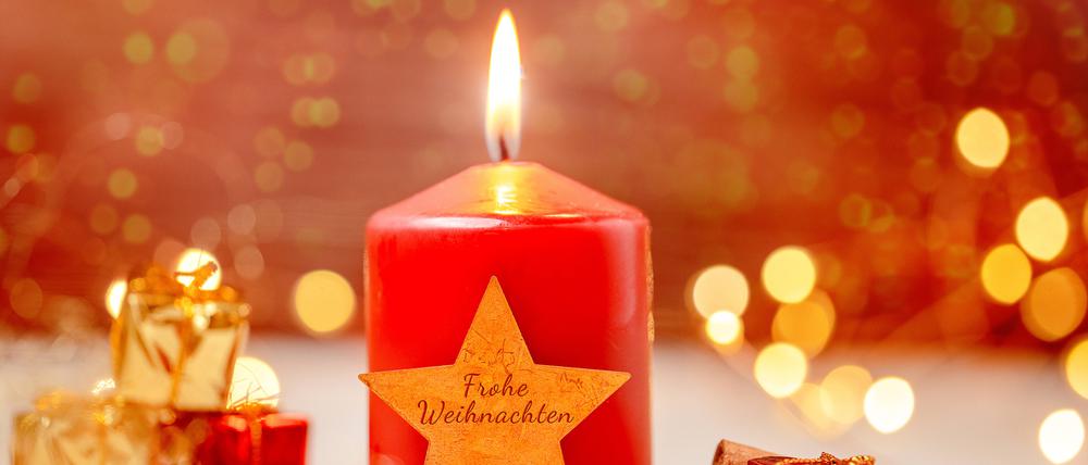 Eine Weihnachtskerze mit der Aufschrift „Frohe Weihnachten“.