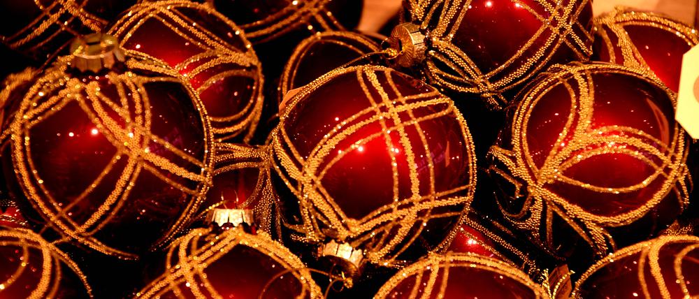 Rote Christbaumkugeln liegen nebeneinander.