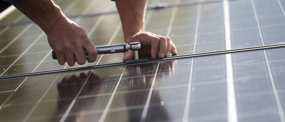 Mitarbeiter der Firma Sontec GmbH montieren Photovoltaikmodule auf dem Dach eines Wohnhauses.