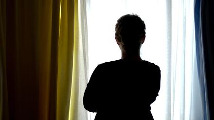 Eine junge Frau steht in einem Zimmer eines Frauenhauses.