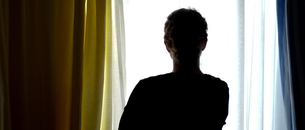 Eine junge Frau steht in einem Zimmer eines Frauenhauses.