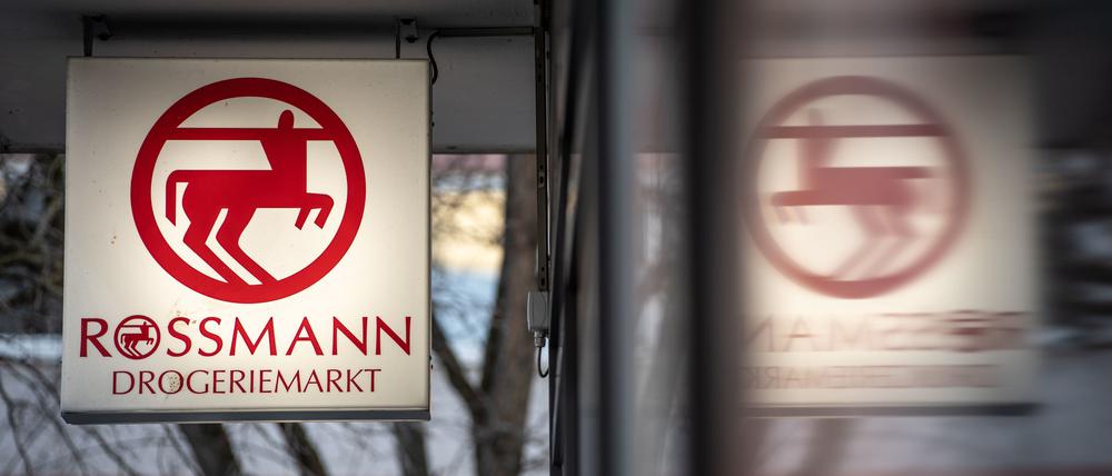 Eine Leuchttafel mit dem Firmenlogo hängt an eine Filiale der Drogeriemarktkette Rossmann.