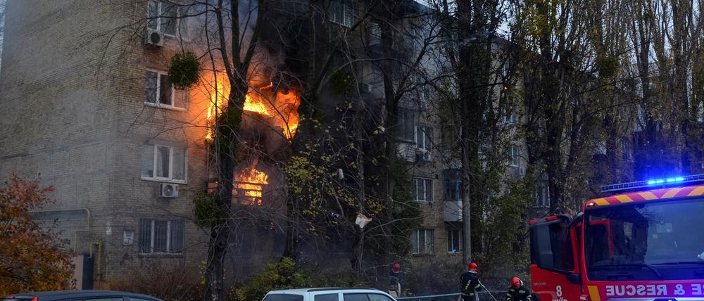 Feuerwehrleute arbeiten daran, ein Feuer in einem Wohnhaus in Kiew zu löschen, das von einem russischen Angriff getroffen wurde.