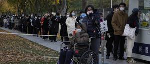 China, Peking: Menschen stehen an einer Teststation an, um sich auf Covid-19 testen zu lassen. 