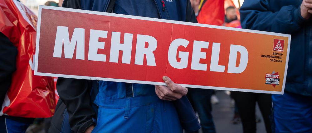 15.11.2022, Sachsen, Görlitz: Ein Mitarbeiter hält ein Schild mit der Aufschrift «Mehr Geld» in den Händen. Beschäftigte von Alstom und Siemens protestieren mit einem Warnstreik vor dem Werk von Siemens Energy. Foto: Paul Glaser/dpa-Zentralbild/dpa +++ dpa-Bildfunk +++