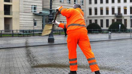 Ein Mitarbeiter der Berliner Stadtreinigung (BSR) streut am 20.01.2014 in Berlin auf dem Pariser Platz Granulat. In der Hauptstadt hat Blitzeis auf den Straßen und Gehwegen zu zahlreichen Unfällen geführt. Die Feuerwehr rief für den Rettungsdienst den Ausnahmezustand aus. Foto: Paul Zinken/dpa +++(c) dpa - Bildfunk+++