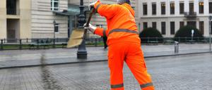 Ein Mitarbeiter der Berliner Stadtreinigung (BSR) streut am 20.01.2014 in Berlin auf dem Pariser Platz Granulat. In der Hauptstadt hat Blitzeis auf den Straßen und Gehwegen zu zahlreichen Unfällen geführt. Die Feuerwehr rief für den Rettungsdienst den Ausnahmezustand aus. Foto: Paul Zinken/dpa +++(c) dpa - Bildfunk+++