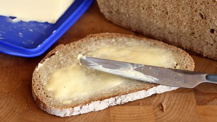Ein Butterbrot liegt auf einem Frühstücksbrett.