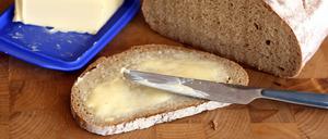 Ein Butterbrot liegt auf einem Frühstücksbrett.