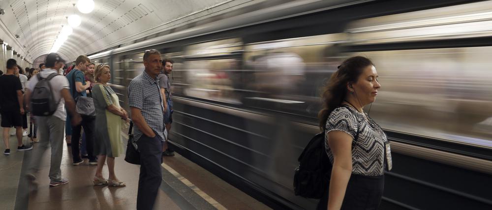Eine Frau im Windzug einer einfahrenden U-Bahn in der russischen Hauptstadt.